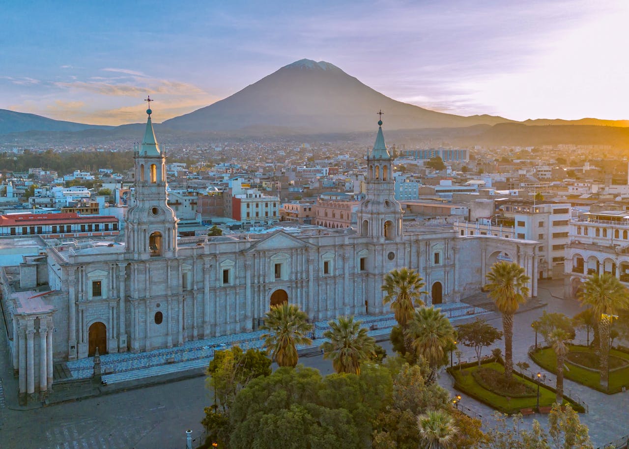 why-choose-us-02 Drone shot of Arequipa's cathedral with El Misti volcano in the background at sunset.